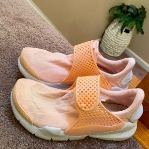 Peach colored lightweight Nike trainers